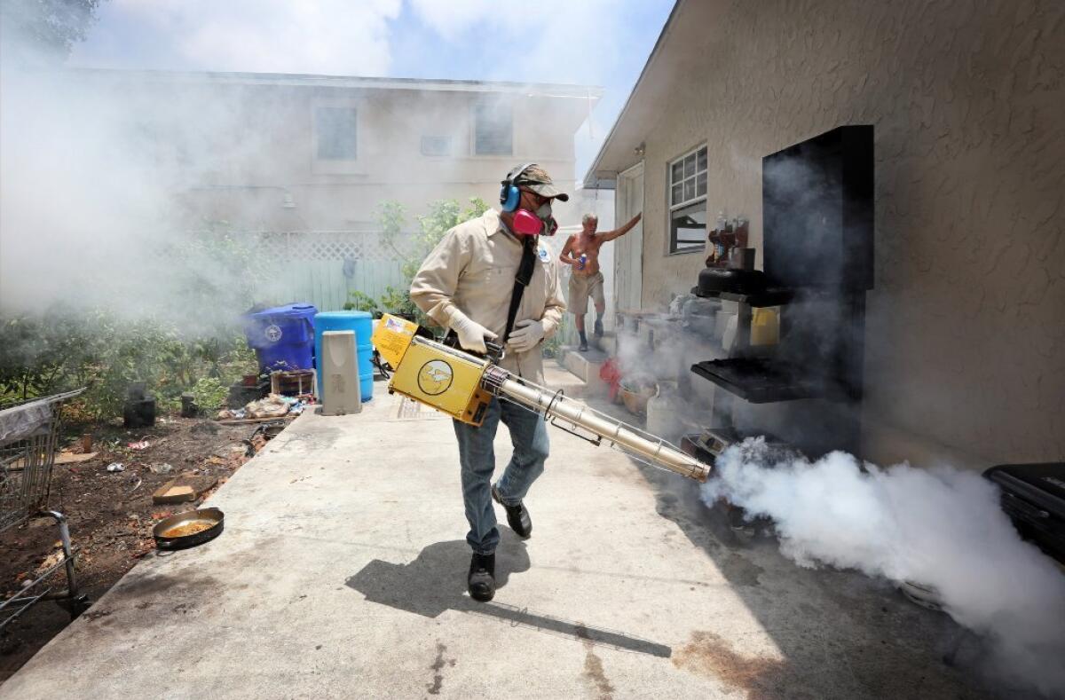 Carlos Varas, a Miami-Dade County mosquito control inspector, sprays pesticide to kill mosquitoes in Miami's Wynwood area. (Emily Michot / Miami Herald)