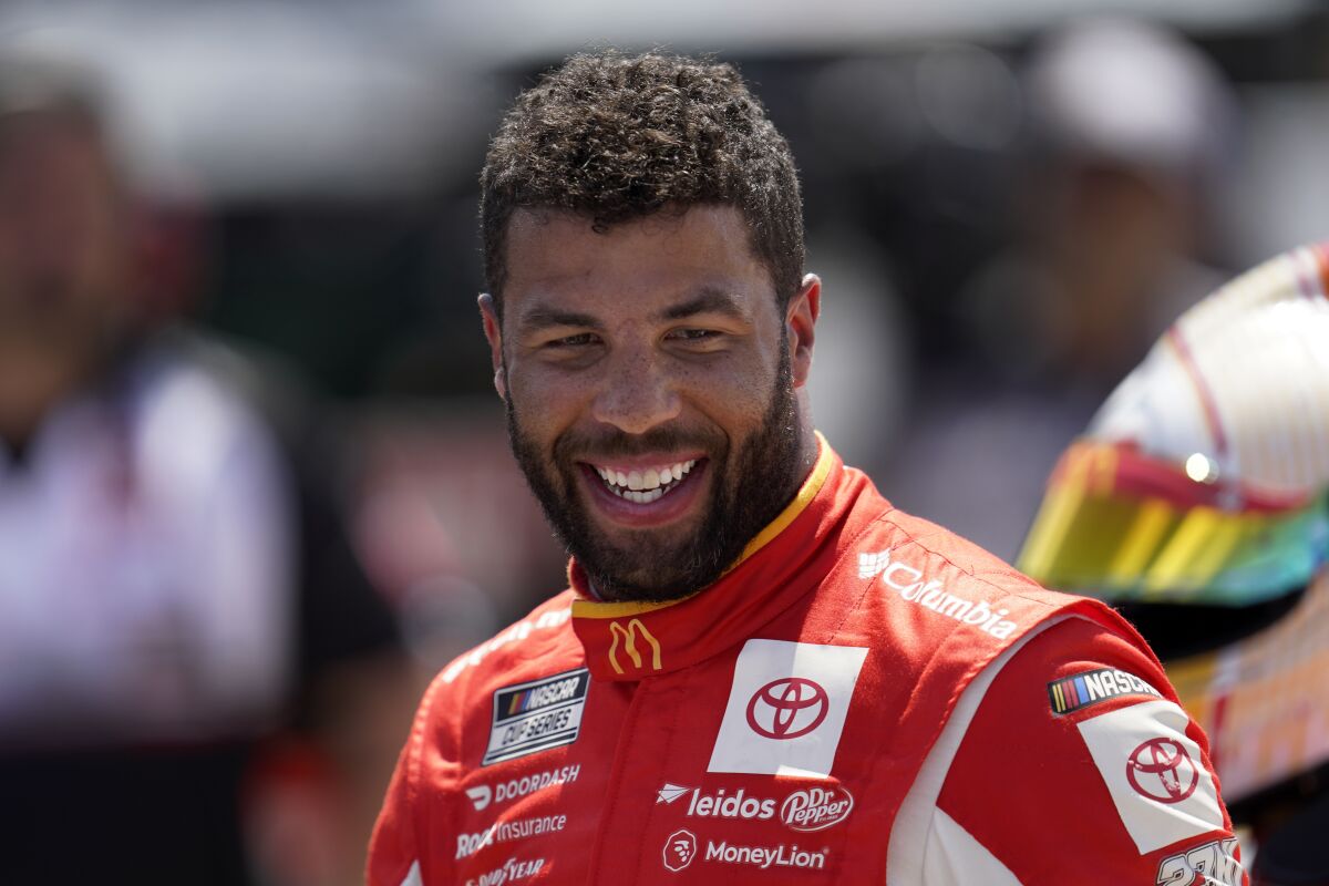 Bubba Wallace smiles during NASCAR Cup Series auto race qualifying at the Michigan International Speedway in Brooklyn, Mich., Saturday, Aug. 6, 2022. Wallace won the pole position. (AP Photo/Paul Sancya)
