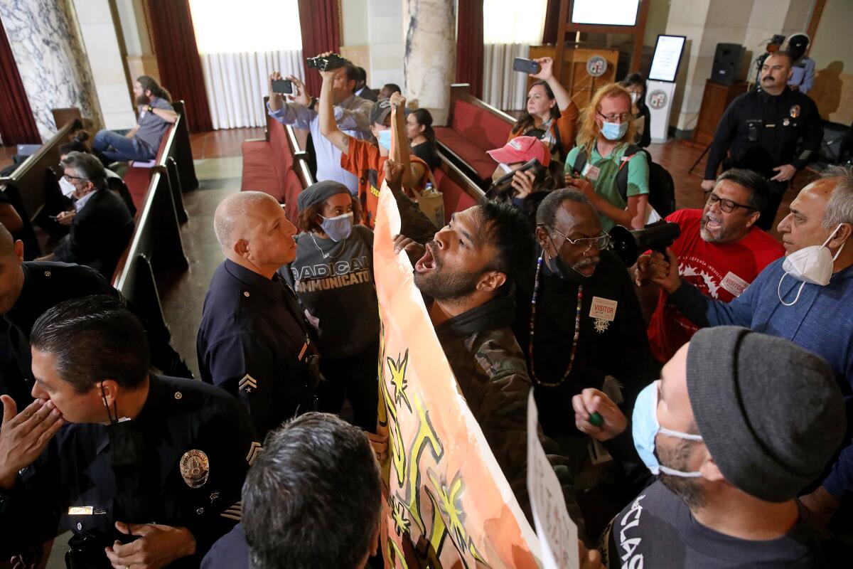 Protesters disrupting the Los Angeles City Council meeting are escorted out