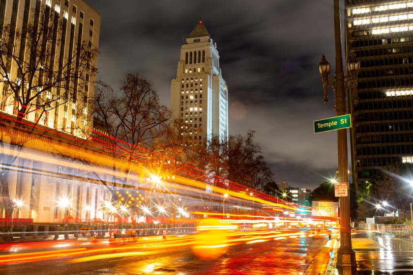 Ominous clouds serve as a backdrop for City Hall at night.