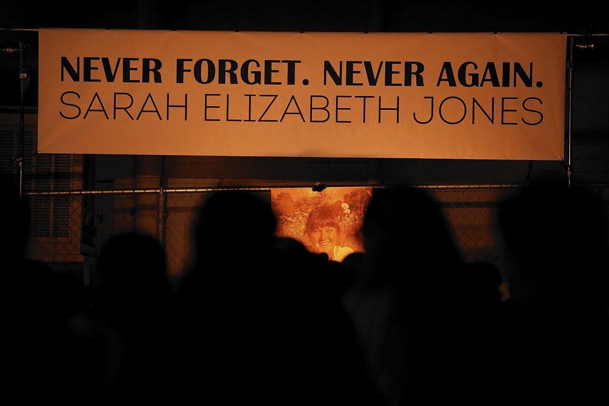 A banner above a photo of Sarah Jones reads, "Never forget. Never again."  