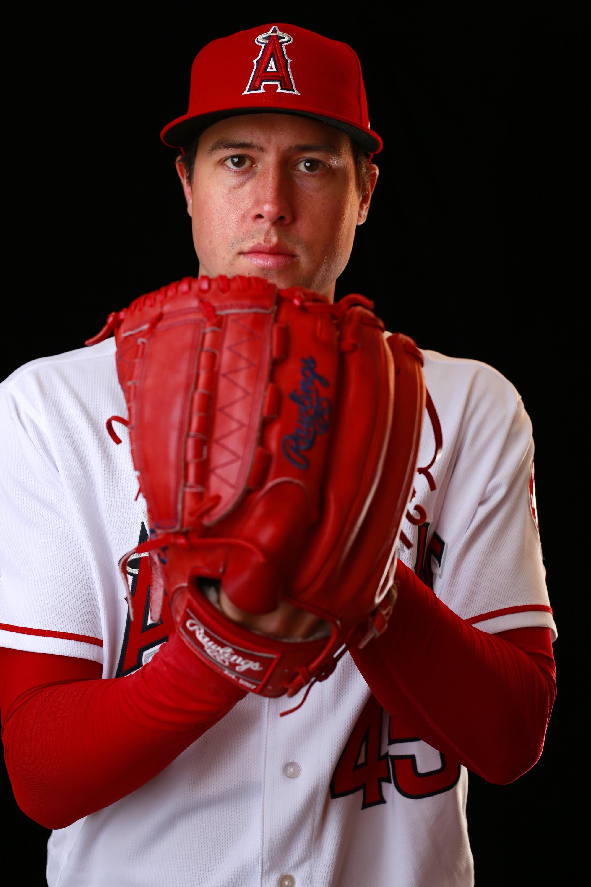 A portrait of Late Angels Tyler Skaggs posing with his left hand in a red Rawlings baseball glove and white uniform