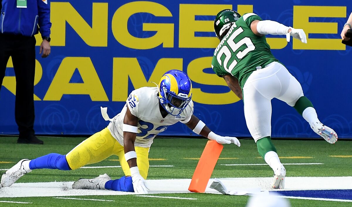 Ty Johnson runs into the end zone ahead of Rams safety Jordan Fuller on an 18-yard pass play on the Jets' first drive.