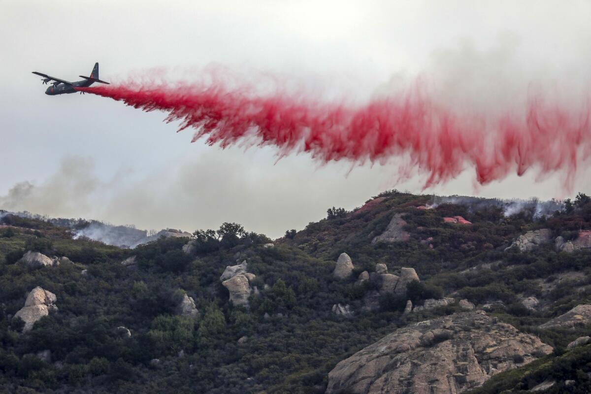 Planes and helicopters fight the Woolsey fire in the Point Mugu State Park on Sunday.