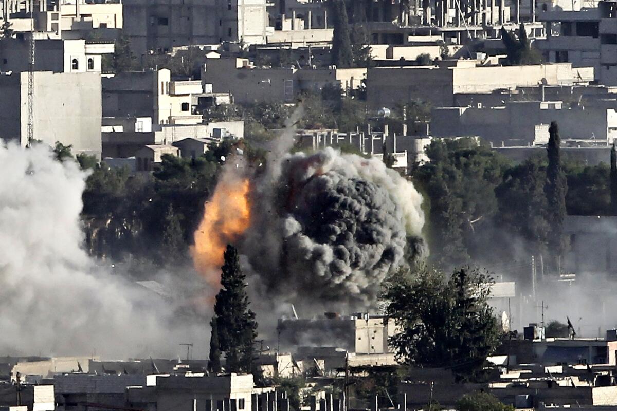 A fire caused by a strike rages in Kobani, Syria, as fighting intensified between Syrian Kurds and Islamic State.