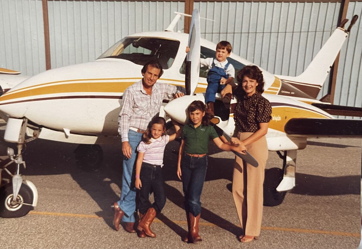 Douglas Happ, his wife and three young children pose in front of the family's Cessna.
