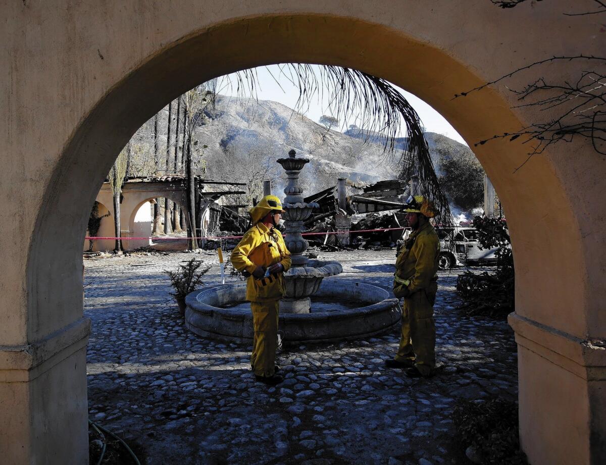 Parts of a historic mansion above Glendora that once belonged to the Singer family of sewing-machine fame continue to smolder from the Colby fire, which grew to about 1,863 acres. It remained about 30% contained Friday evening.