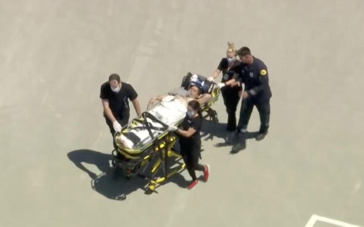 An aerial view of a wounded firefighter being transported by gurney