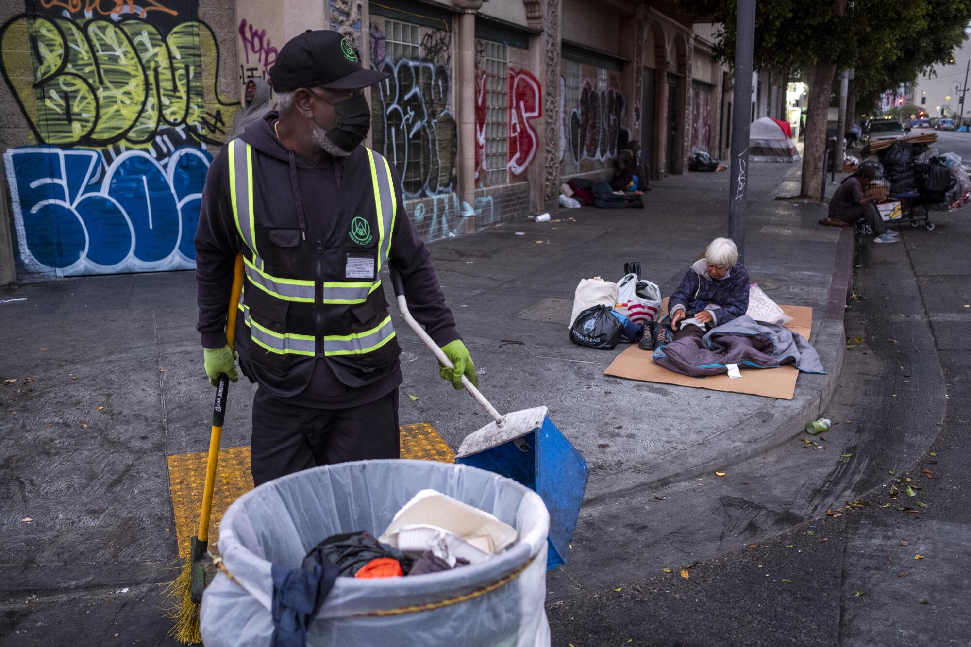 A woman is just waking up on the sidewalk as Urban Alchemy practitioner Marcus Pelham