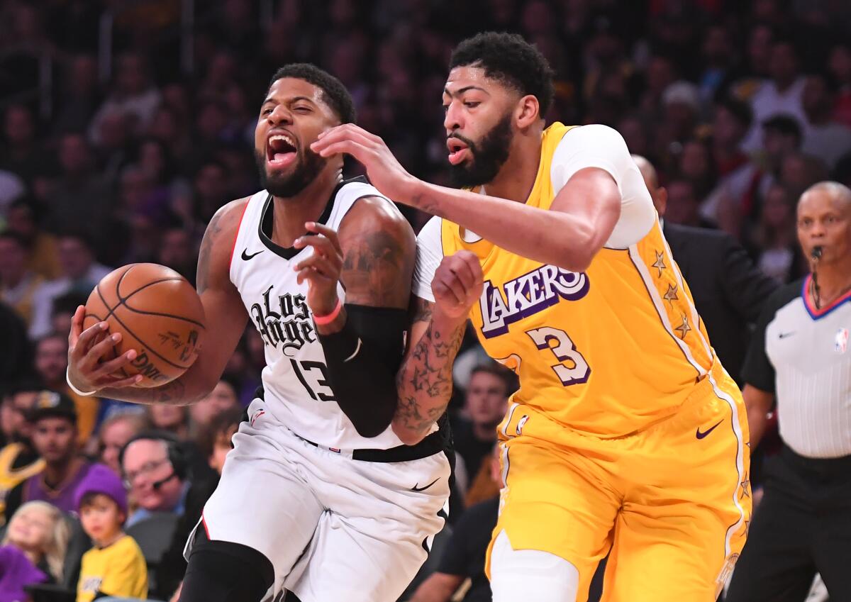 Clippers forward Paul George tries to drive past Lakers forward Anthony Davis during a game Dec. 25, 2019.