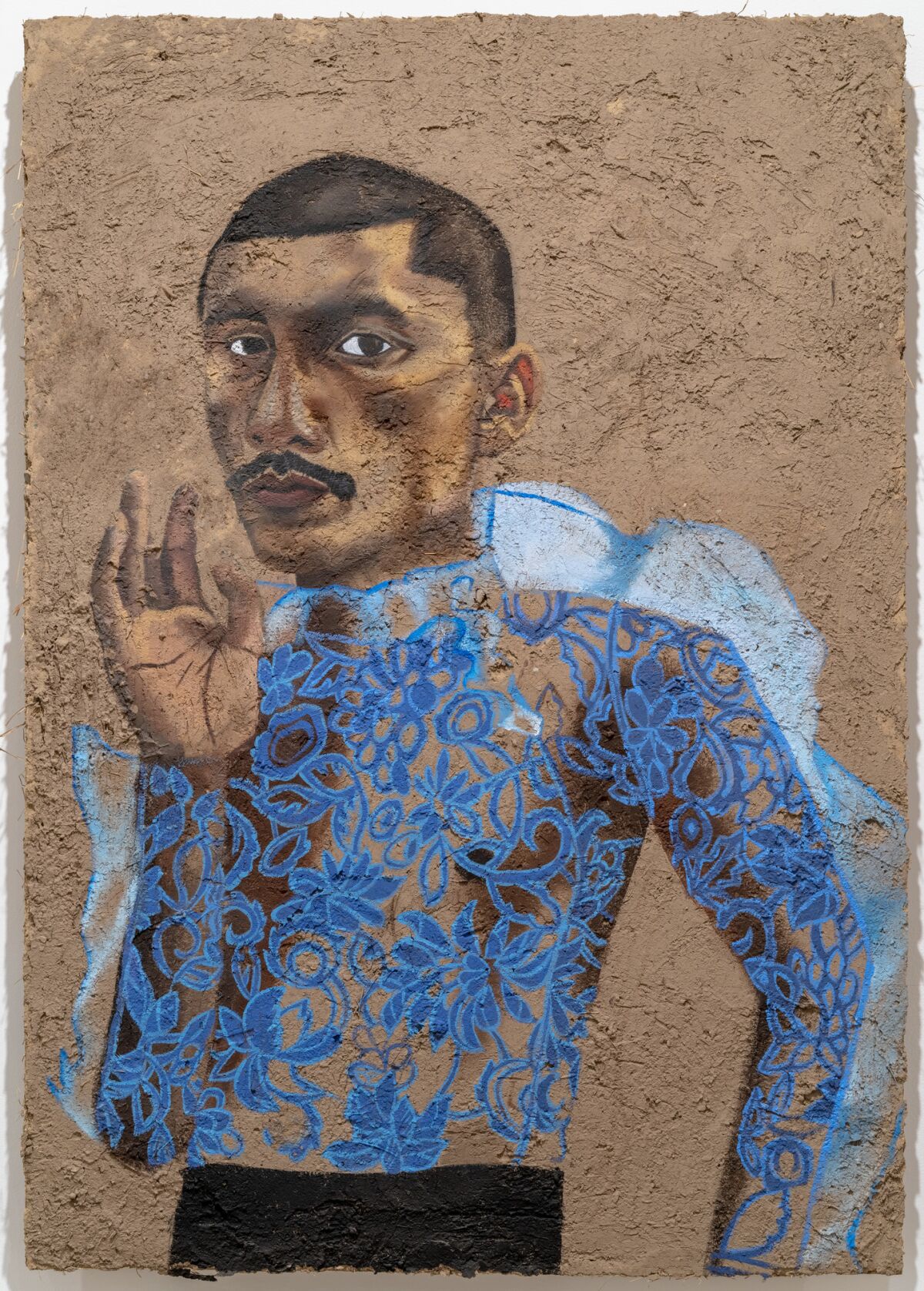 A portrait of performance artist Sebastian Hernandez painted on adobe by Rafa Esparza