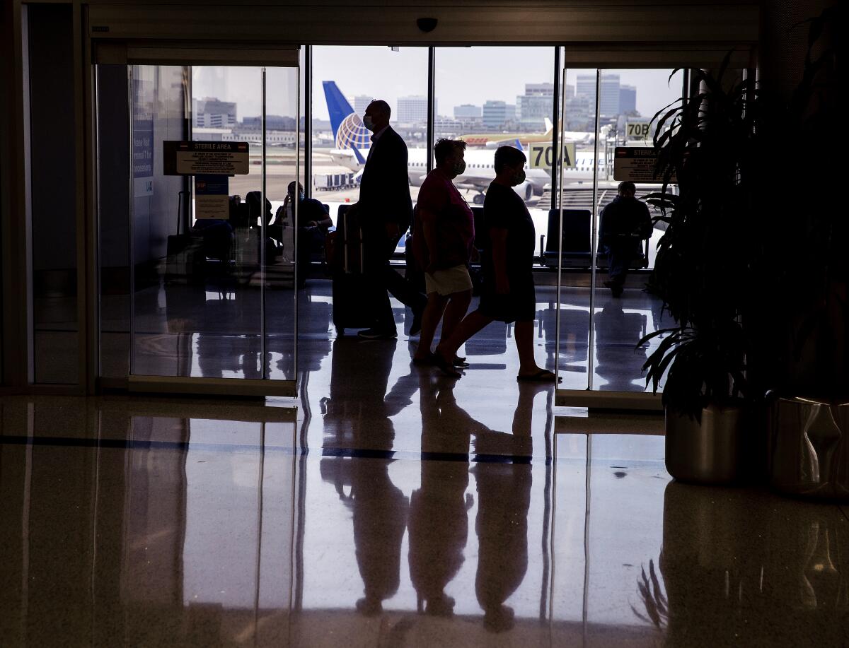 People walk through an airport terminal