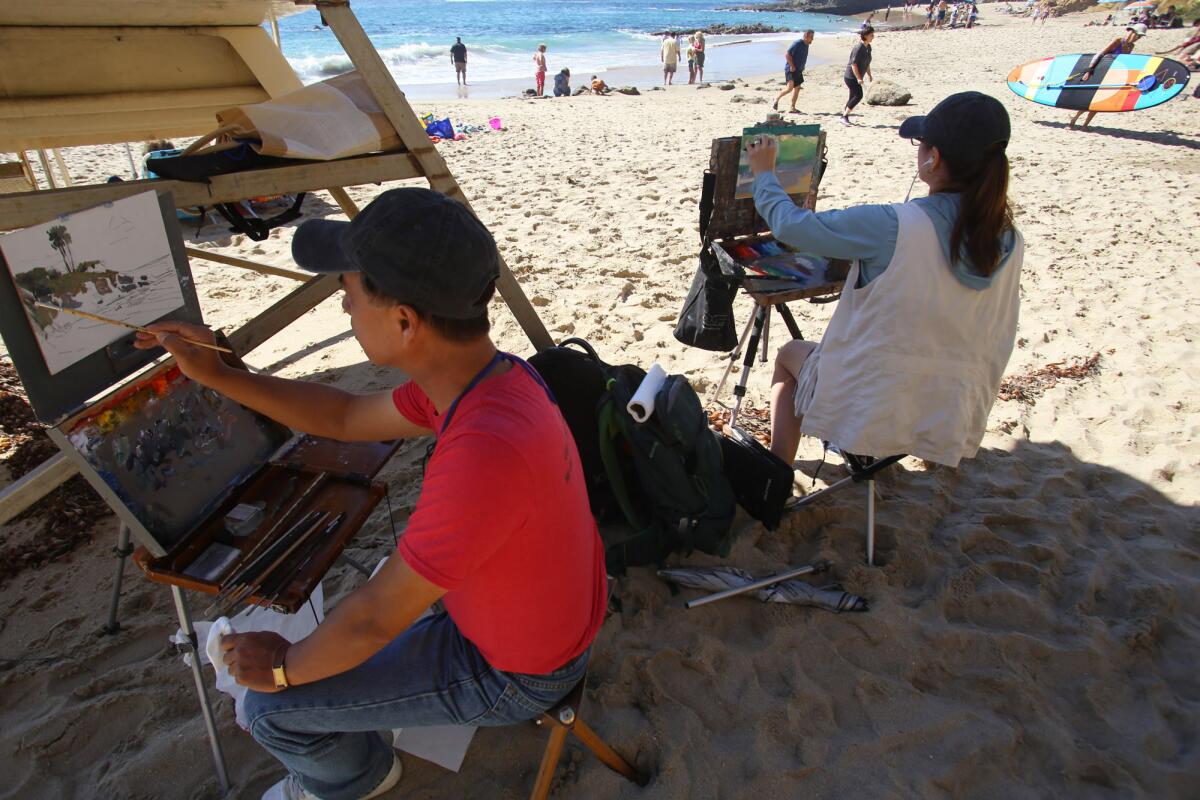 Corona resident Calvin Liang, left, and Suzie Baker of Houston sought inspiration in the Laguna Beach sand as they took part in the Quick Draw competition.