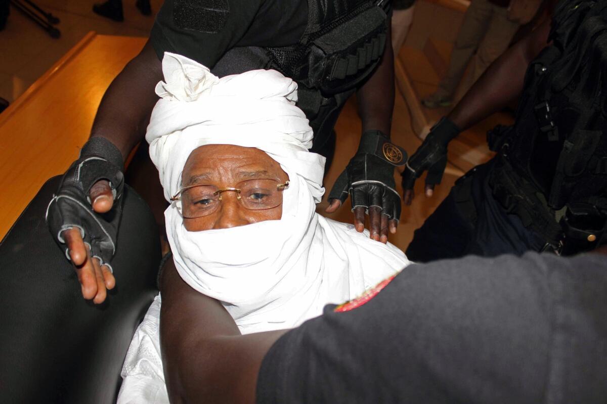 Security personnel surround former Chadian dictator Hissene Habre inside the court in Dakar, Senegal, on July 20. The trial of former Chadian dictator Hissene Habre, accused of overseeing the deaths of thousands, had a chaotic beginning Monday as security forces ushered the ex-leader into and then out of the Senegal courtroom amid protests by his supporters.