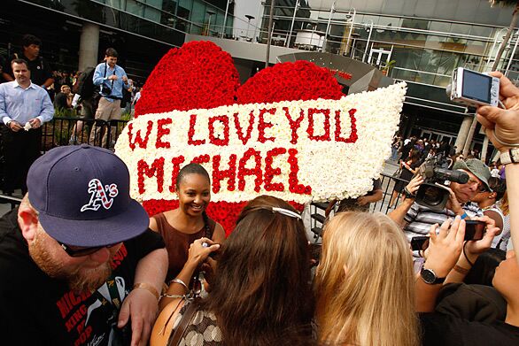 Fans stand around a heart made of roses in memory of Michael Jackson in front of Staples Center.