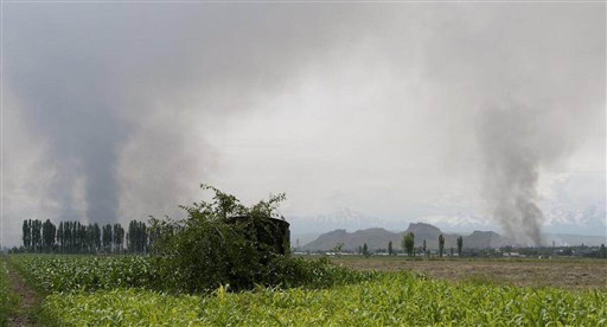 Smoke rises from the burning villages of ethnic Uzbek set on fire by the Kyrgyz attackers, in villages near Osh, southern Kyrgyzstan, Saturday, June 12, 2010. The country's second-largest city, Osh, slid into chaos Friday when gangs of young Kyrgyz men armed with firearms and metal rods marched on Uzbek neighborhoods and set their homes on fire. Thousands of terrified ethnic Uzbeks were fleeing toward the nearby border with Uzbekistan. (AP Photo/D. Dalton Bennett)