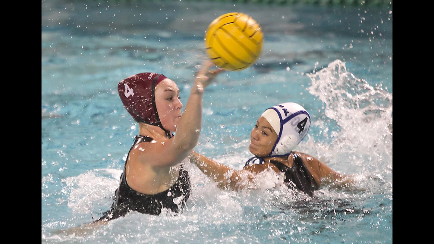 Laguna's Isabel Riches turns and shoots for a score as Los Alamitos' Kristin Weaver tries to defend in girls water polo action on Wednesday.