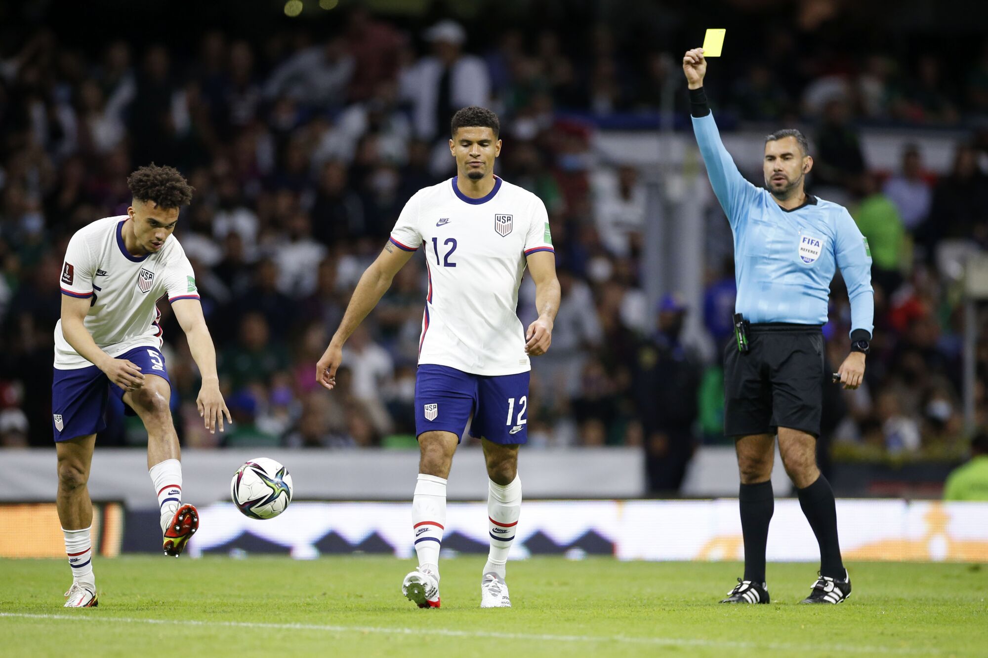U.S. defender Miles Robinson (12) receives a yellow card during the first half Thursday.