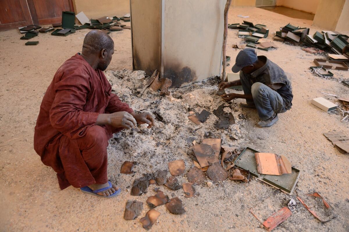 Men sort through the rubble at the Ahmed Baba Institute in Timbuktu, Mali.