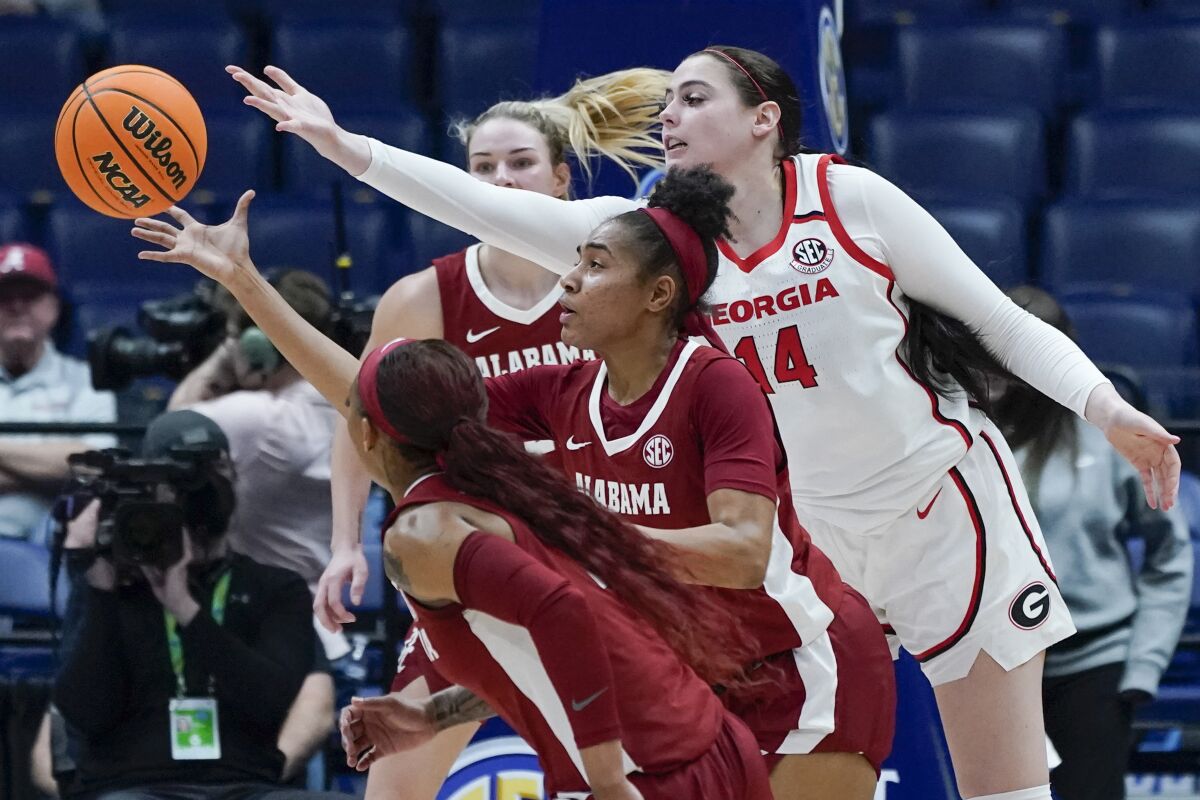 Georgia's Jenna Staiti (14) reaches over Alabama's Brittany Davis in the first half of an NCAA college basketball game at the women's Southeastern Conference tournament Thursday, March 3, 2022, in Nashville, Tenn. (AP Photo/Mark Humphrey)