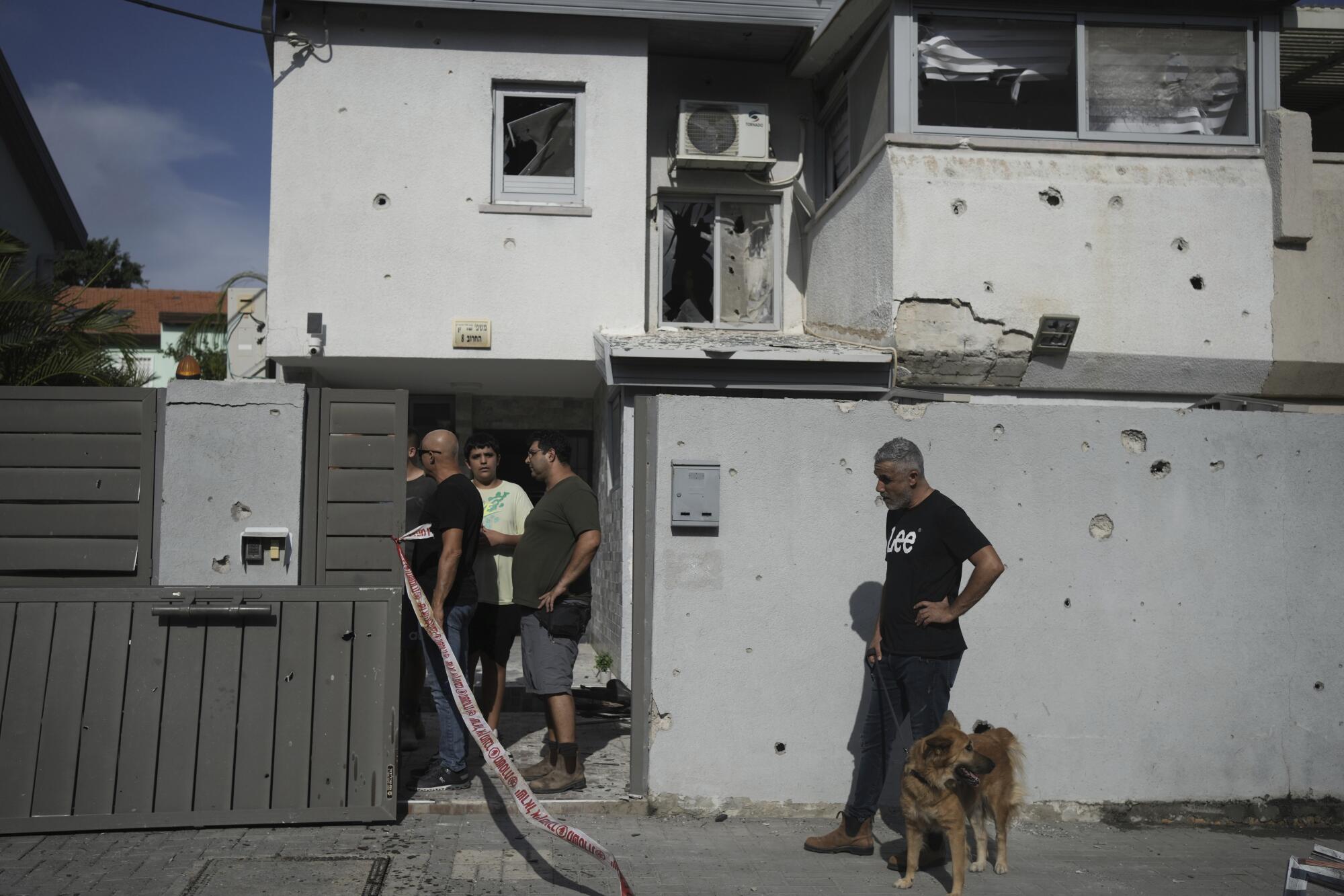 People inspecting house damaged by militant rocket fire in Israel