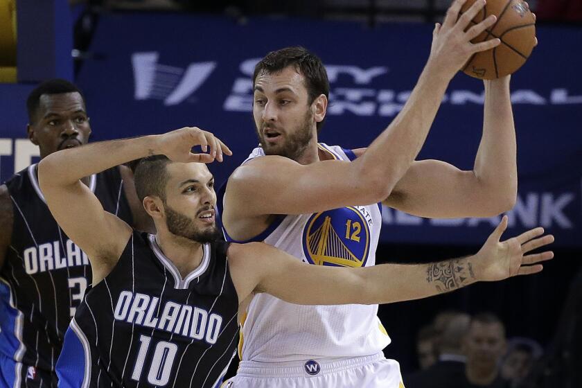 Warriors center Andrew Bogut keeps the ball out of the reach of Magic guard Evan Fournier during the first half of a game on Dec. 2.