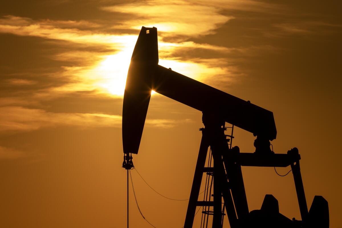 The sun sets behind a pumpjack in Texas in 2021. 