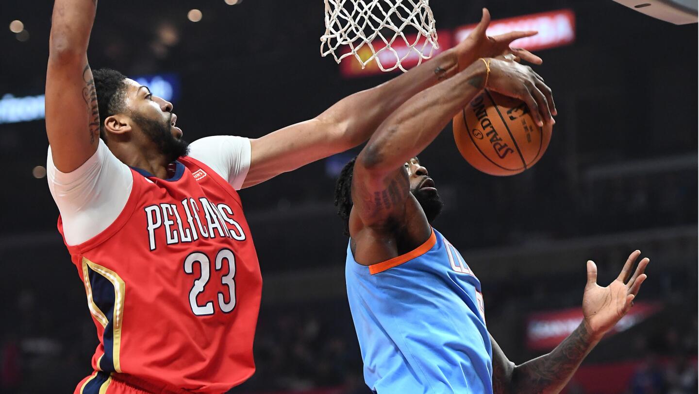 Clippers center DeAndre Jordan grabs a rebound from Pelicans Anthony Davis during the first half of a game Tuesday at Staples Center.