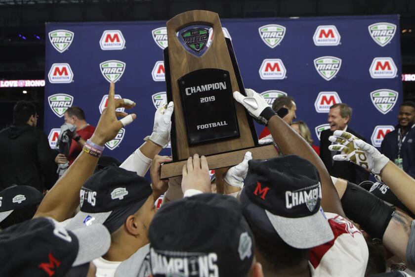 FILE - In this Dec. 7, 2019, file photo, members of the Miami of Ohio team hold the champion trophy after the Mid-American Conference championship NCAA college football game against Central Michigan, in Detroit. The Mid-American Conference on Saturday, Aug. 8, 2020, became the first league competing at college football’s highest level to cancel its fall season because of COVID-19 concerns. With the MAC’s 12 schools facing a significant financial burden by trying to maintain costly coronavirus protocols, the conference’s university presidents made the decision to explore a spring season. (AP Photo/Carlos Osorio, File)
