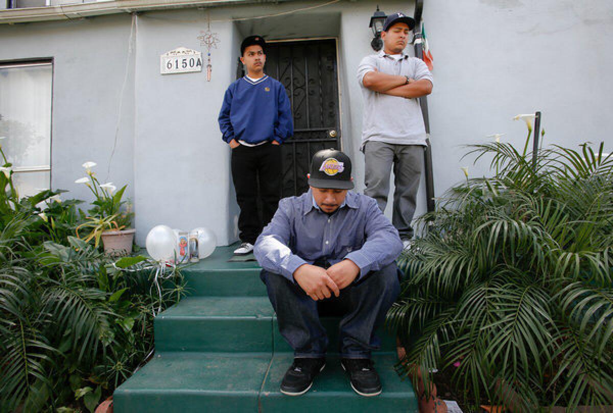 Three sons mourn the loss of their father Leonardo Fernandez on the front steps of his home in East Los Angeles on April 1.