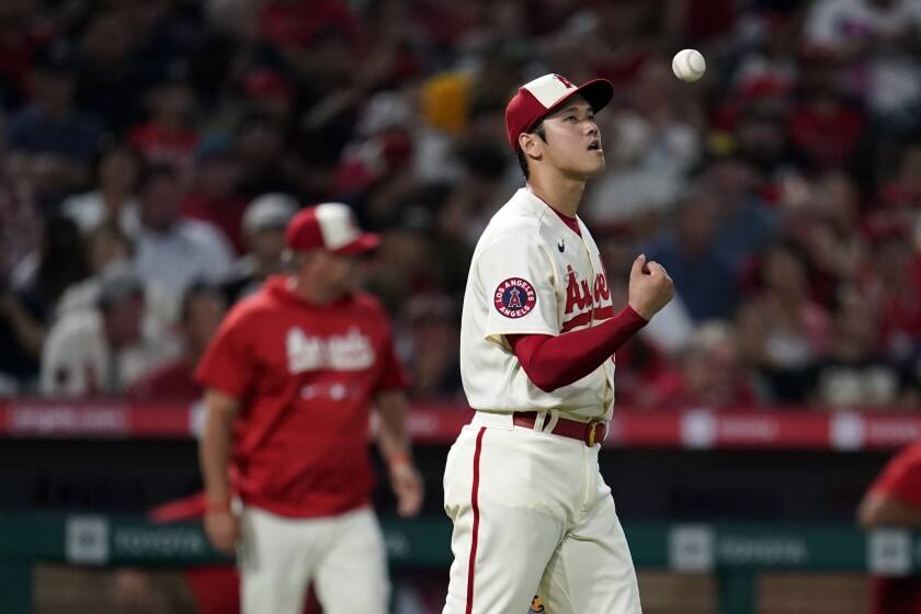 Angels pitcher Shohei Ohtani tosses the baseball in the air.