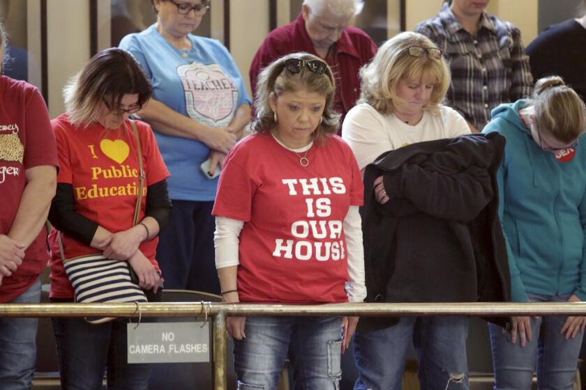 Teachers and supporters in the Senate gallery bow their heads in prayer as they protest at the Capitol in Oklahoma City on Friday, April 6, 2018. Oklahoma is the second state where teachers have gone on strike this year. (Mike Simons/Tulsa World via AP)