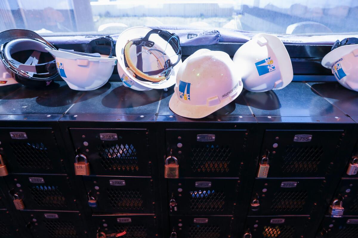 A row of white hard hats, some overturned, sit atop black lockers.
