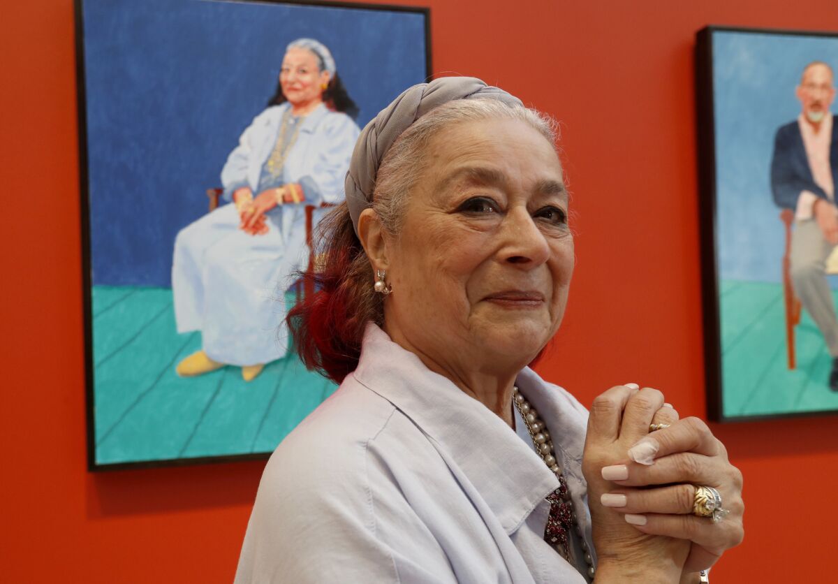 Joan Agajanian Quinn beside the portrait Hockney painted of her. (Luis Sinco / Los Angeles Times)