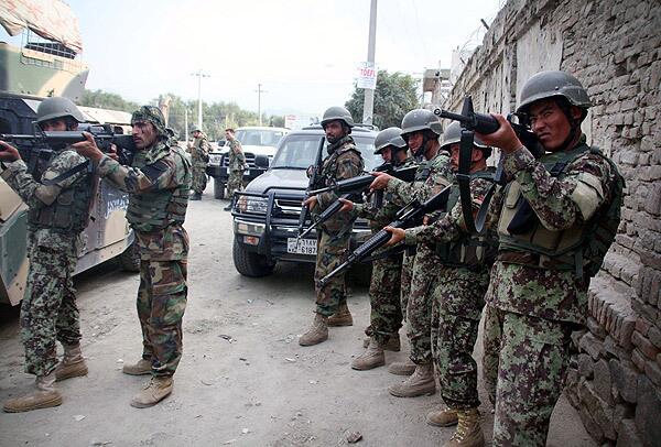 Afghan soldiers take position at the scene after several armed Taliban militants launched attacks in Kabul. Several Taliban suicide bombers were reportedly holed up in a multi-story building near several foreign embassies and NATO's International Security Assistance Force headquarters.