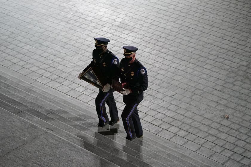 An honor guard carries an urn with the cremated remains of U.S. Capitol Police officer Brian Sicknick and folded flag up the steps of the U.S Capitol to lie in honor in the Rotunda, Tuesday, Feb. 2, 2021, in Washington. (AP Photo/Alex Brandon, Pool)
