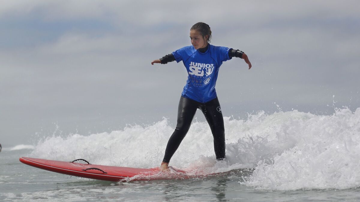Liv Stone surfs during the Junior Seau Foundation's Youth Adaptive Surfing Camp in Del Mar on Saturday.