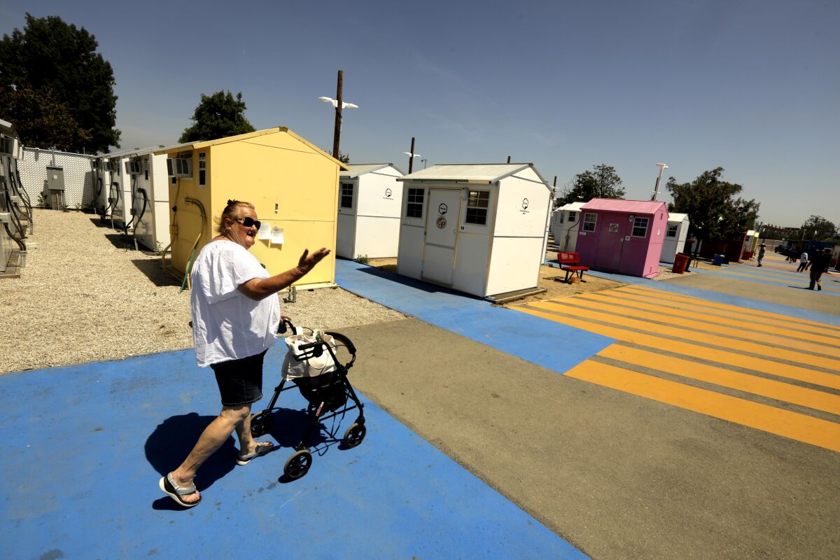 Beth Thompson makes her way to her home at the Alexandria Park Tiny Home Village in North Hollywood.