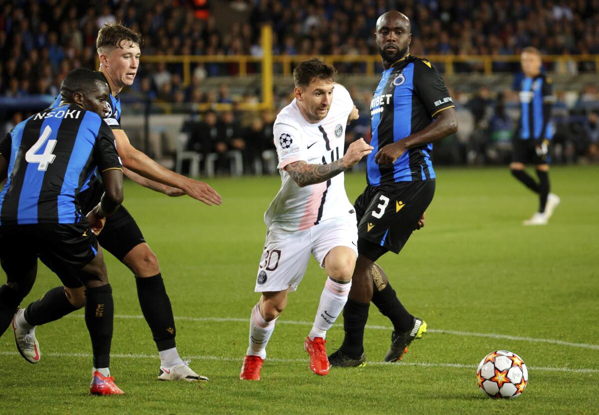 PSG's Lionel Messi, center, goes after the ball against Brugge's Stanley Nsoki, left, and Brugge's Eder Balanta, right, during the Champions League Group A soccer match between Club Brugge and PSG at the Jan Breydel stadium in Bruges, Belgium, Wednesday, Sept. 15, 2021. (AP Photo/Olivier Matthys)