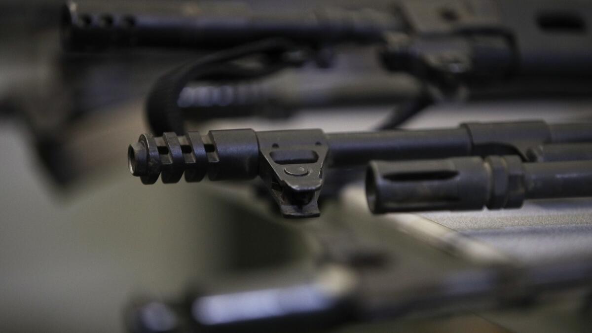 Illegally possessed firearms seized by authorities are displayed at an Oct. 9 news conference in Los Angeles.