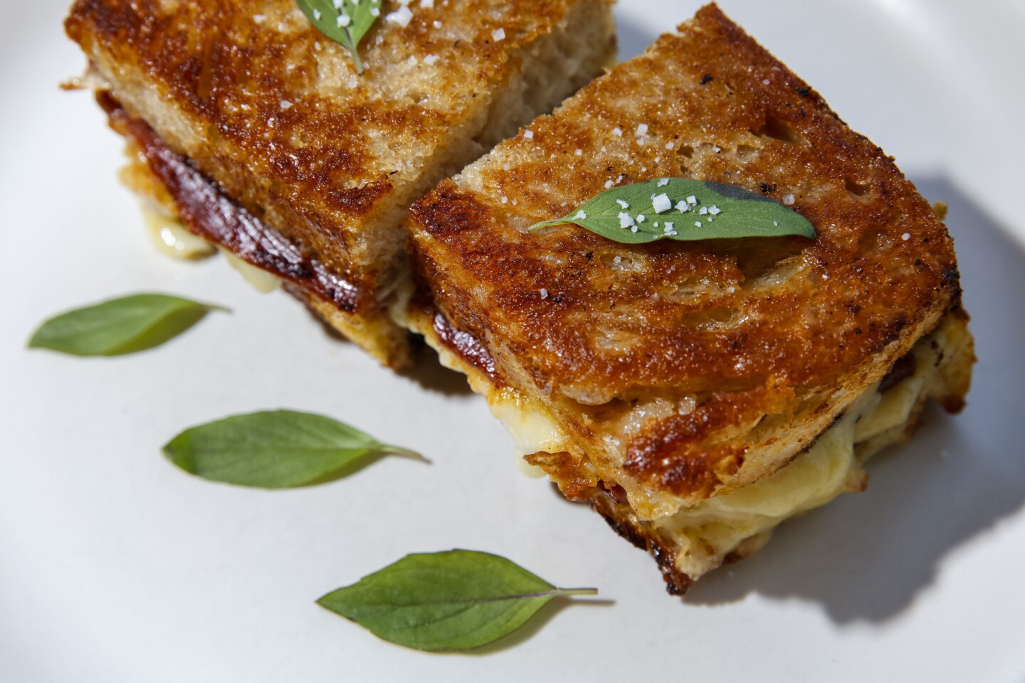 From the lunch and dinner menus at Winsome, a speck and comte grilled cheese sandwich with rustic toast, thai basil and pear mostarda.