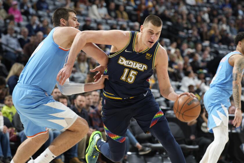 Denver Nuggets center Nikola Jokic, right, drives to the rim past Los Angeles Clippers center Ivica Zubac in the first half of an NBA basketball game Tuesday, March 22, 2022, in Denver. (AP Photo/David Zalubowski)
