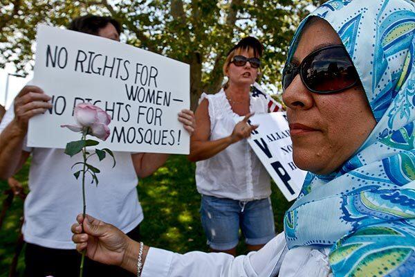 Mosque supporter Gabriella Ayoub presents a rose to opponents of the proposed house of worship during their rally across the street from where the Islamic Center of Temecula Valley currently meets. See full story