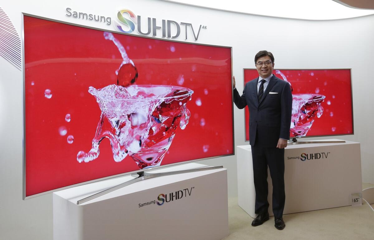 Kim Hyun-seok, head of Samsung Electronics' TV business, poses with a mart TV during a news conference in Seoul. The company has drawn criticism for the voice-recognition technology it uses in its TV remote controls.
