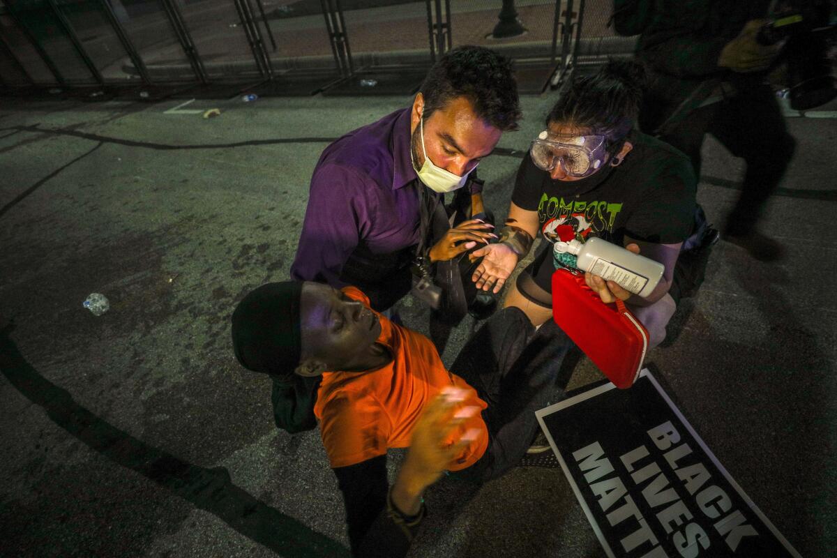 Protesters help a man during demonstrations  over the shooting  in Kenosha