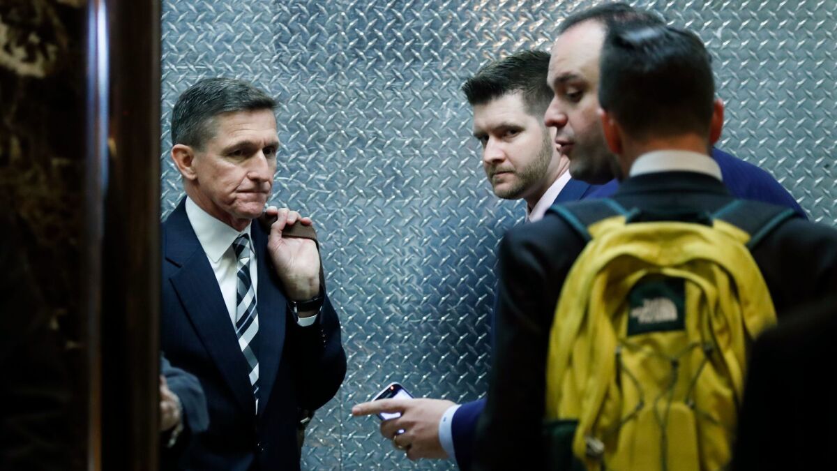 Retired Lt. Gen. Michael Flynn, left, and his son Michael G. Flynn, second from left, board an elevator at Trump Tower in New York on Nov. 17, 2016.