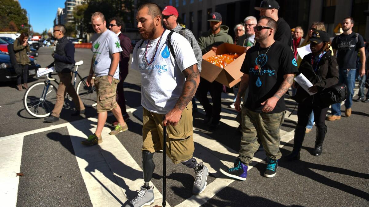 Army veteran and triple-amputee Jose Martinez of Los Angeles, center, and other veterans and supporters of medical marijuana march to the Department of Veterans Affairs and the White House to bring awareness to the need to legalize medical marijuana.