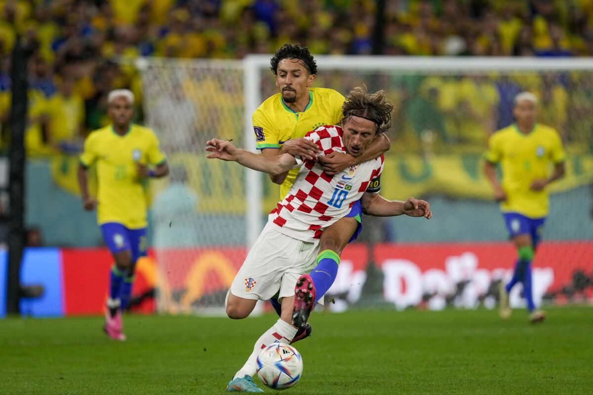 Marquinhos, atrás, abraza y derriba a Luka Modric, de Croacia, durante el partido de cuartos de final 