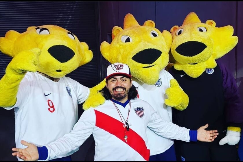 U.S. men's soccer fan Ray Noriega poses with mascots during one of his trips to support the team.