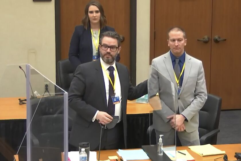 In this screen grab from video, defense attorney Eric Nelson, left, defendant and former Minneapolis police officer Derek Chauvin, right, and Nelson's assistant Amy Voss, back, introduce themselves to jurors as Hennepin County Judge Peter Cahill presides over jury selection in the trial of Chauvin Wednesday, March 17, 2021 at the Hennepin County Courthouse in Minneapolis, Minn. Chauvin is charged in the May 25, 2020 death of George Floyd. (Court TV, via AP, Pool)
